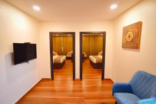 a living room with a couch and a tv at Hotel Swagat Suites in Haridwār