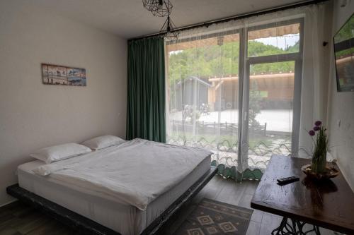 - une chambre avec un lit et une grande fenêtre dans l'établissement Bârlogul Vikingilor, à Şotrile