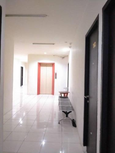 un pasillo con un banco y una puerta roja en Anno Guest House en Makassar