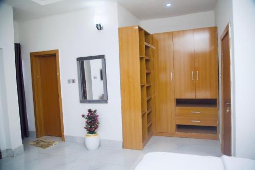 a room with a wooden closet and a mirror at Oasis Villa Lekki in Lekki