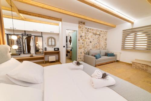 ein Schlafzimmer mit einem großen weißen Bett und ein Wohnzimmer in der Unterkunft Domus Inn Luxury Apartments in Parga