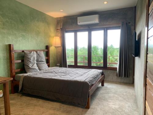 sypialnia z łóżkiem i dużym oknem w obiekcie COCO HOME Homestay(โคโค่โฮม) w mieście Ban Mo Kaeng Taek