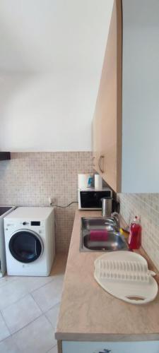 eine Küche mit einer Spüle und einer Mikrowelle in der Unterkunft Kate in Peraia