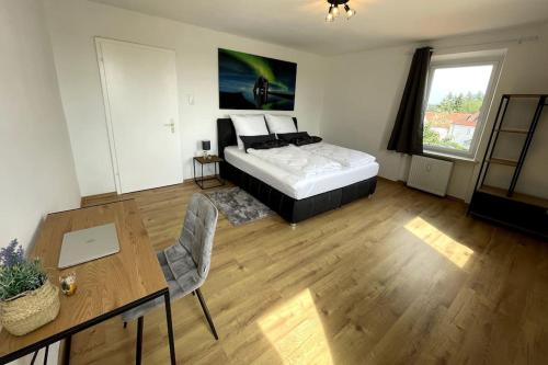 a bedroom with a bed and a table in a room at Homestay - Luxus Ferienwohnung in Bad Griesbach