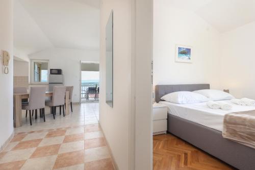 a bedroom with a bed and a dining room at Sea view by Moro 3 in Malinska