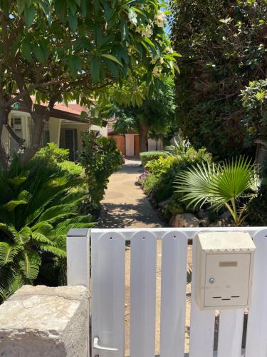 a white fence with a mailbox in front of a yard at Breezot Yam in Nahariyya