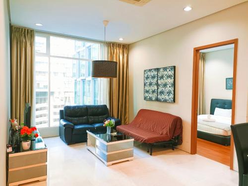 uma sala de estar com um sofá e uma cama em Soho Suites Klcc By Sweet Home em Kuala Lumpur