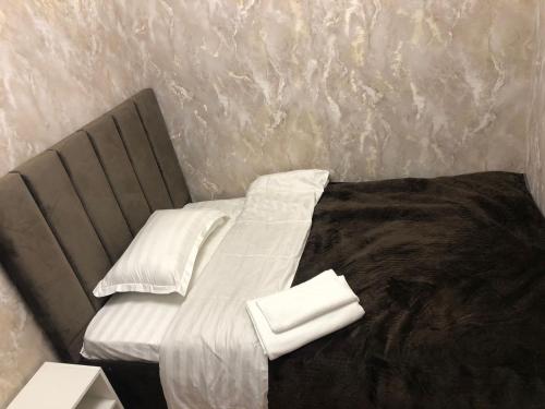 a bed with white sheets and pillows on it at Hotel LION Almaty in Almaty