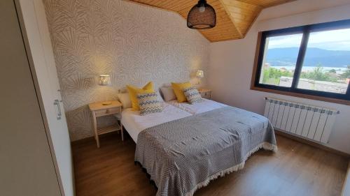 una camera da letto con un letto con cuscini gialli e una finestra di Visita costa de Galicia desde la Villa de Arcade a Arcade