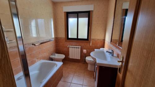 ein Badezimmer mit zwei Waschbecken, einer Badewanne und einem WC in der Unterkunft Visita costa de Galicia desde la Villa de Arcade in Arcade