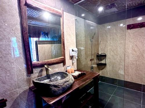 a bathroom with a stone sink and a mirror at Bac Ha Charm Stay in Bắc Hà