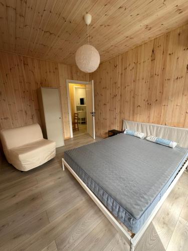 1 dormitorio con 1 cama y 1 silla en Buxus Villas Shekvetili, en Shekhvetili