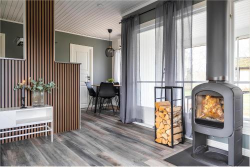 - un salon doté d'un poêle à bois dans l'établissement Renovated cottage with SPA located 200 m from the sea, à Ljungbyholm