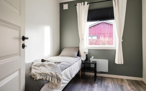 niewielka sypialnia z łóżkiem i oknem w obiekcie Renovated cottage with SPA located 200 m from the sea w mieście Ljungbyholm