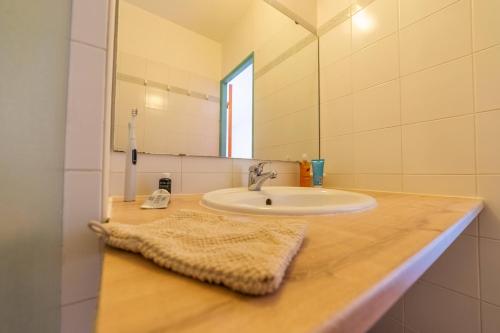 a bathroom counter with a sink and a mirror at VVF Narbonne-Plage Saint-Pierre-la-Mer in Fleury