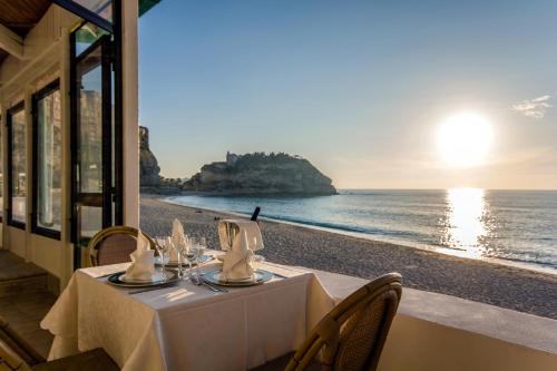 a table with a view of the beach at Le Roccette Mare Beach Hotel & Restaurant in Tropea