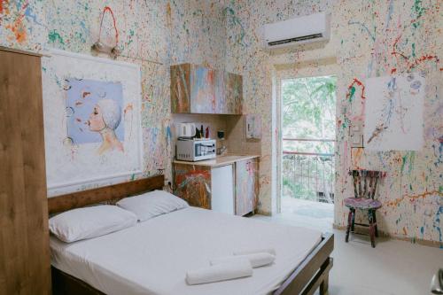 海法的住宿－Hotel Loui Talpiot，壁纸客房内的一间卧室配有一张床