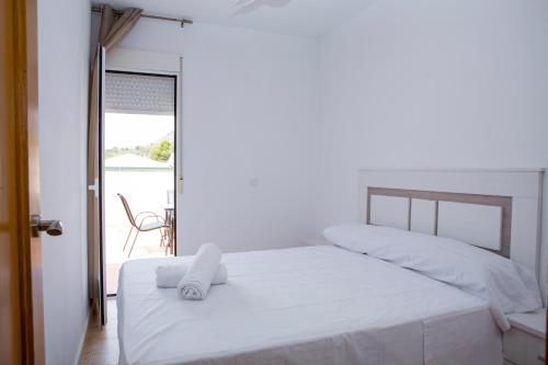 1 dormitorio con cama blanca y balcón en Apartamento Completo Luna Llena de Calasparra, en Calasparra