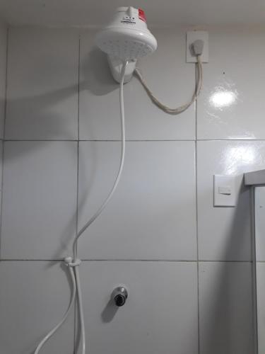 a shower with a hose attached to a wall at Chalés Rosados in Serra de São Bento