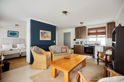 a living room with a couch and a table and a kitchen at The Rondebosch in Cape Town