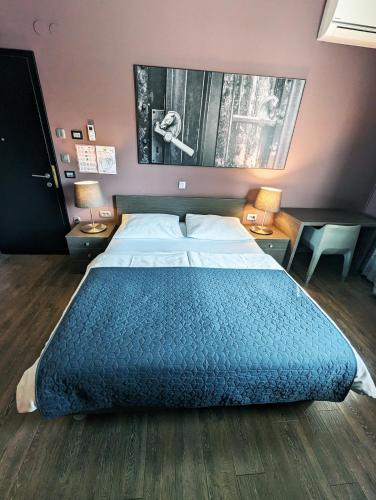 a large bed in a bedroom with two tables and two lamps at Nitro Rooms in Ljubljana