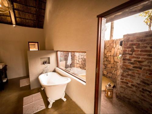 uma casa de banho com uma grande janela e uma banheira em Bushwa Private Game Lodge em Vaalwater