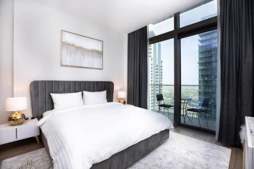 a bedroom with a white bed and a large window at LUXURY 1 BR Apartment at Marina Gate Jumeirah Living in Dubai