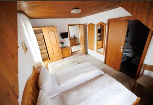 ein Schlafzimmer mit einem großen weißen Bett in einem Zimmer in der Unterkunft Drexl Gasthof Shiro in Schondorf am Ammersee