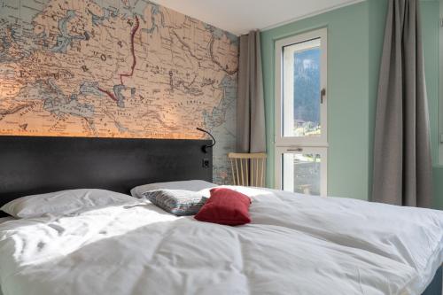 a bedroom with a white bed with a map on the wall at Emma's B&B - Self Check-in Hotel in Lungern