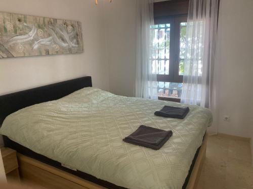een slaapkamer met een bed met twee handdoeken erop bij Casa Lisanofa in Orihuela