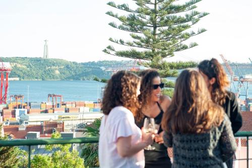 a group of women standing on a balcony with wine glasses at Cheese & Wine Lapa in Lisbon