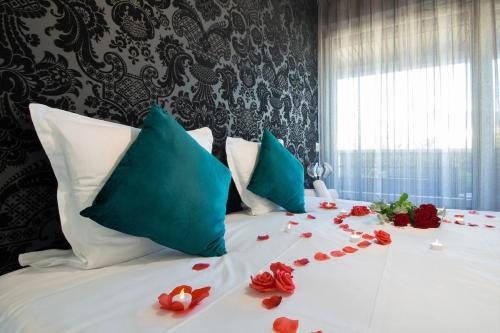 - un lit avec des pétales de rose rouge dans l'établissement Golden Beach parking proche du lac, à Annecy