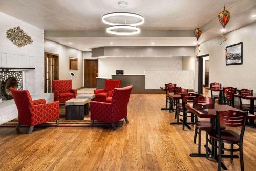 a large room with tables and chairs and a fireplace at Ramada by Wyndham Albuquerque Airport in Albuquerque