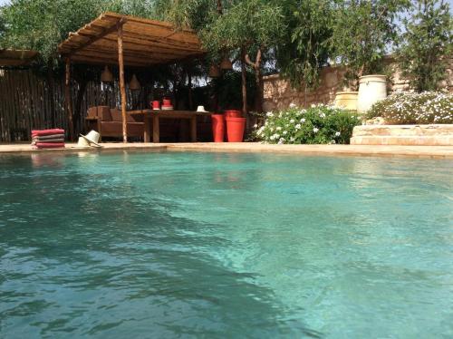 una piscina de agua azul en un patio en Villa 202 commentaires 5 étoiles sur 3 sites, en Essaouira