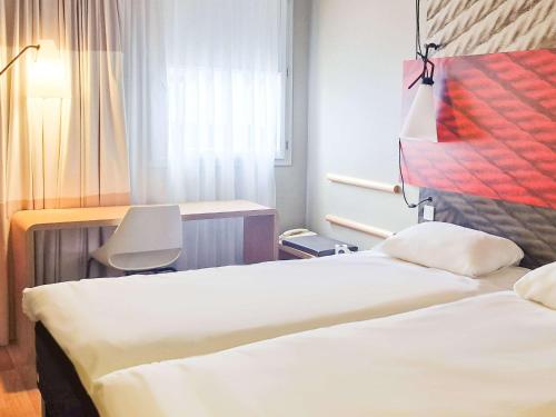 Zimmer mit 2 Betten, einem Schreibtisch und einem Stuhl in der Unterkunft Hotel ibis Dijon Centre Clemenceau in Dijon