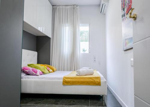 Bett in einem kleinen Zimmer mit Fenster in der Unterkunft Playa 4 a solo 3 min - Apartamento en Castelldefels in Castelldefels