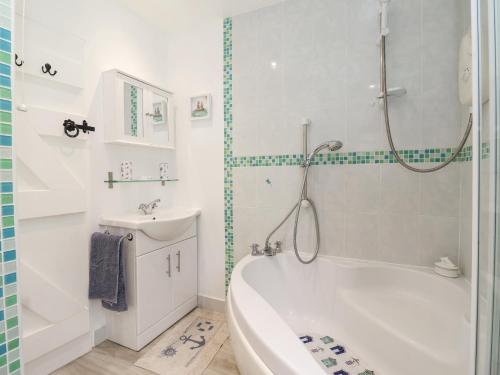 ein weißes Badezimmer mit einer Badewanne und einem Waschbecken in der Unterkunft Wavecrest in Hornsea