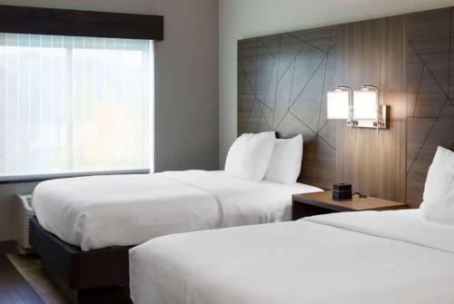 a hotel room with two beds and a window at La Quinta by Wyndham Edmond in Edmond
