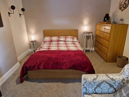 a small bedroom with a bed and a dresser at Cosy Riverside home in Llanwrda