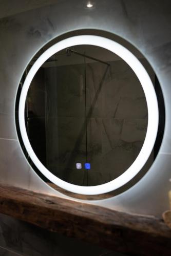 a round mirror on a wall in a room at Bârlogul Vikingilor in Şotrile