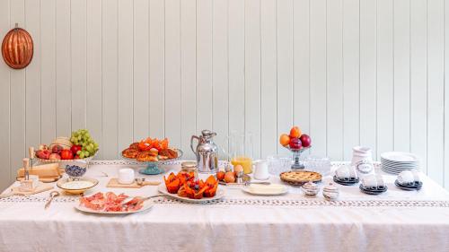 - une table avec des fruits et des assiettes de nourriture dans l'établissement Villa Galimberti Maison De Charme, à Osnago