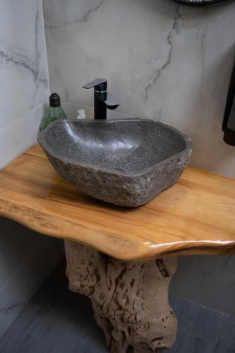 a stone sink on a wooden table in a bathroom at Bârlogul Vikingilor in Şotrile
