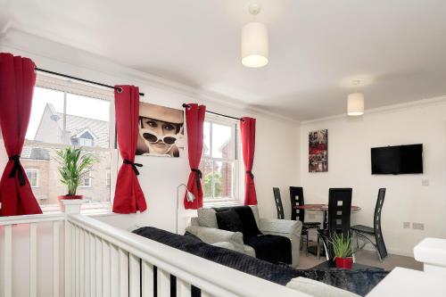 a living room with red curtains and a table at Garland Rd Colchester in Colchester