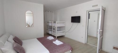 a white bedroom with a bed and a mirror at Hotel & Rooms Lombrelle in Mostar