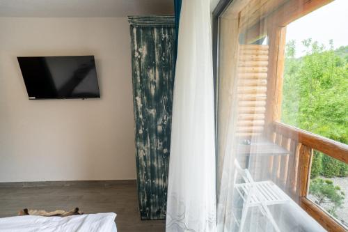 a room with a window with a television and a chair at Bârlogul Vikingilor in Şotrile