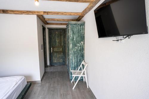a room with a tv on the wall and a chair at Bârlogul Vikingilor in Şotrile