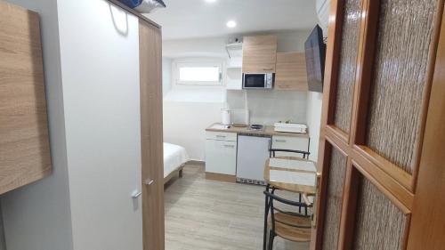uma pequena cozinha com uma mesa e uma cadeira num quarto em 2023 Bruno - wifi and parking available em Portorož