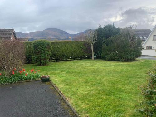 a yard with a green lawn with flowers and a hedge at Fairways Villa Newcastle in Newcastle