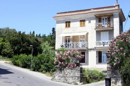 a white building with flowers in front of a street at 2023 Bruno - wifi and parking available in Portorož