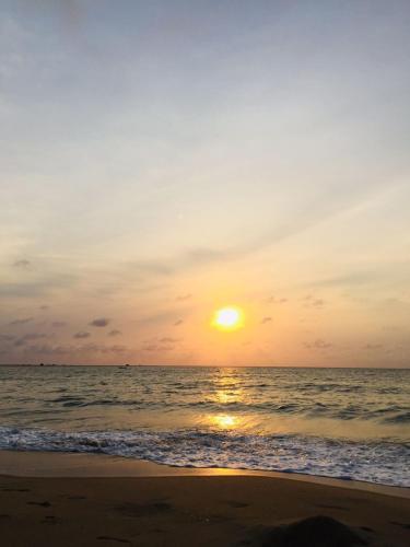 a sunset on the beach with the ocean at Sea Sand Resort in Kalpitiya